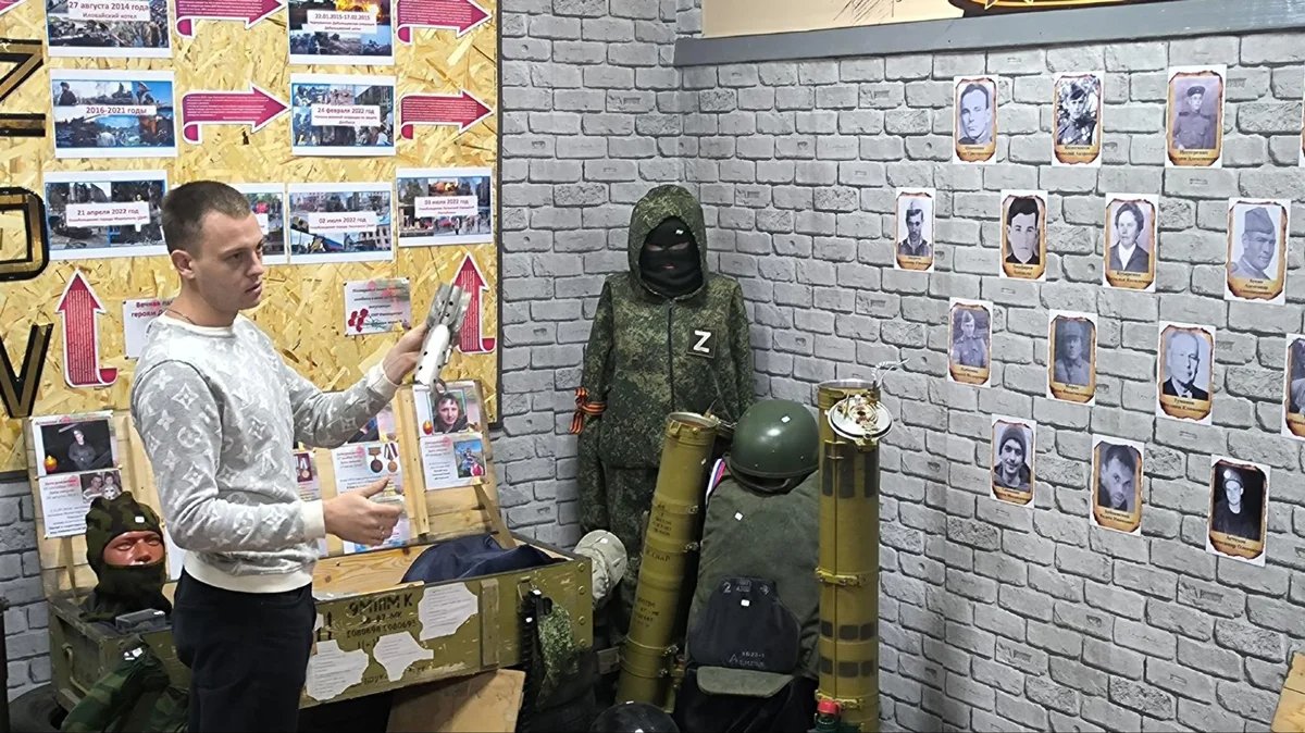 Igor Pugachev stands in front of a memorial to Russian soldiers killed in Ukraine in his school’s museum in Rovenky, in the Russian-occupied Luhansk region. Photo: Rovenky School No. 3