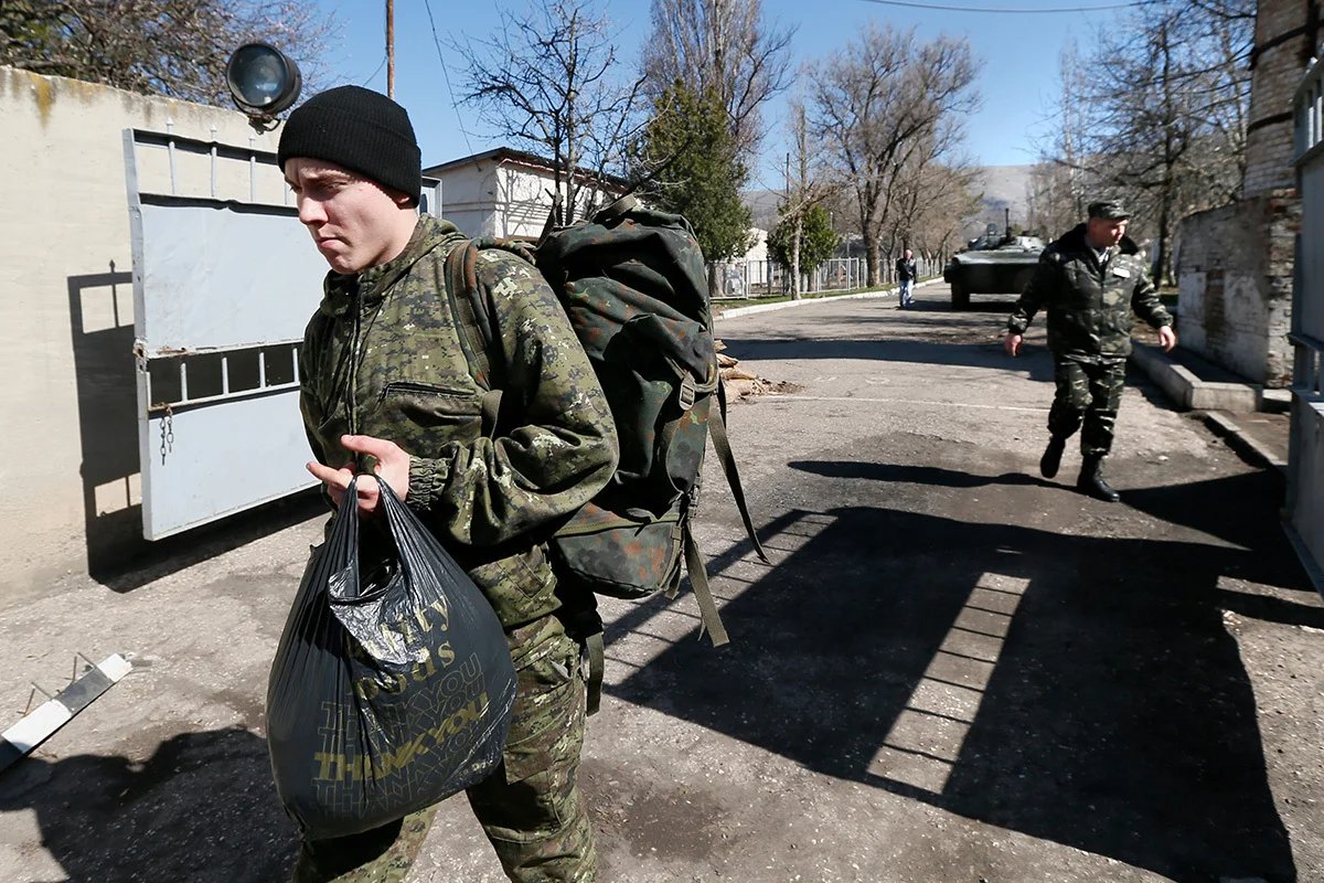 Ukrainian servicemen leave the territory of their military base seized by Russian soldiers in the village of Perevalnoye, outside Simferopol, 21 March 2014. Photo: EPA/YURI KOCHETKOV