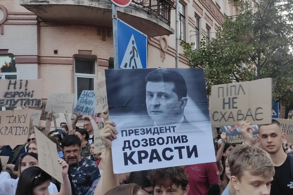 Protesters hold up a sign reading “The president allowed stealing” during a demonstration in Kyiv on 23 July 2025. Photo: EPA/Rostyslav Averchuk