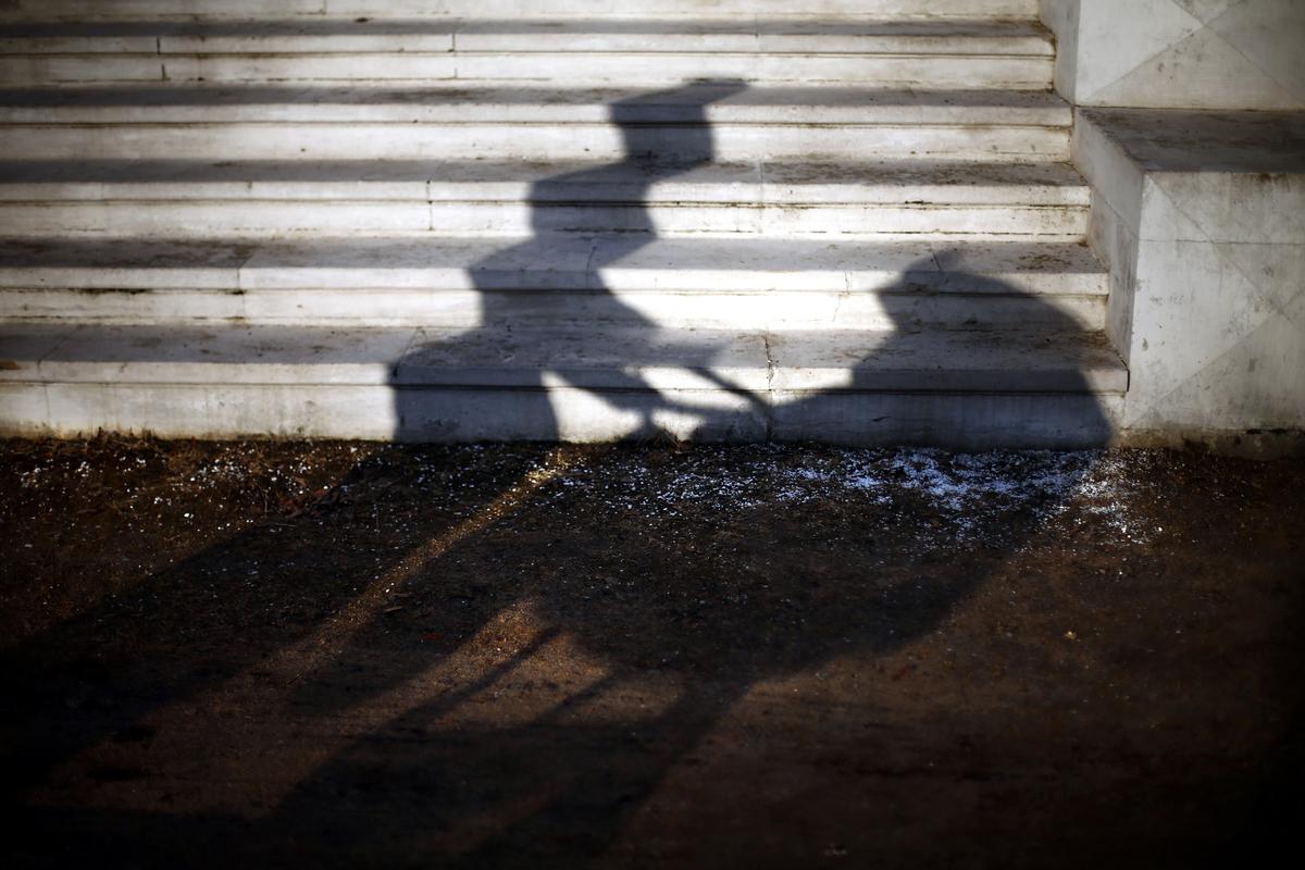 The shadow of a woman pushing a stroller through Moscow’s Ostafyevo Park. Photo: EPA / MAXIM SHIPENKOV