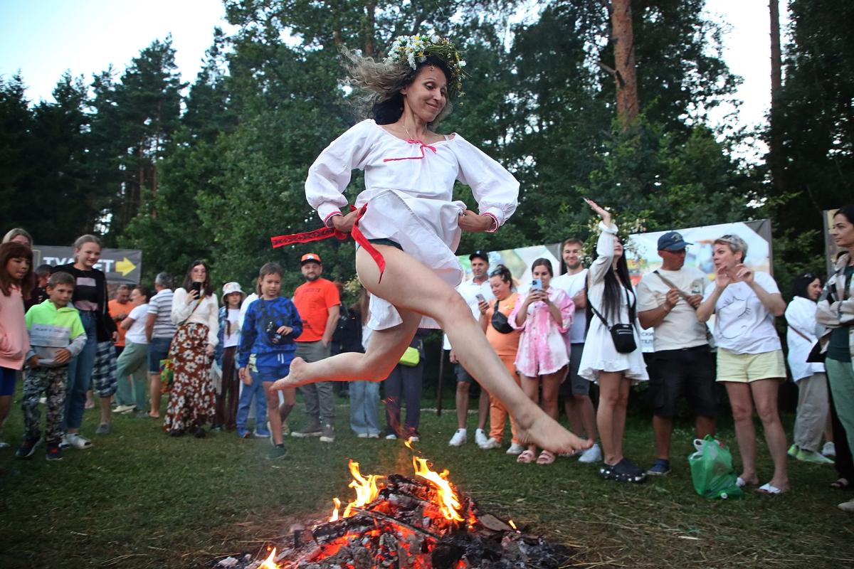 A woman jumps over a bonfire at the Ivan Kupala fertility and self-purification festival near Moscow, 6 July 2024. Photo: EPA-EFE/MAXIM SHIPENKOV