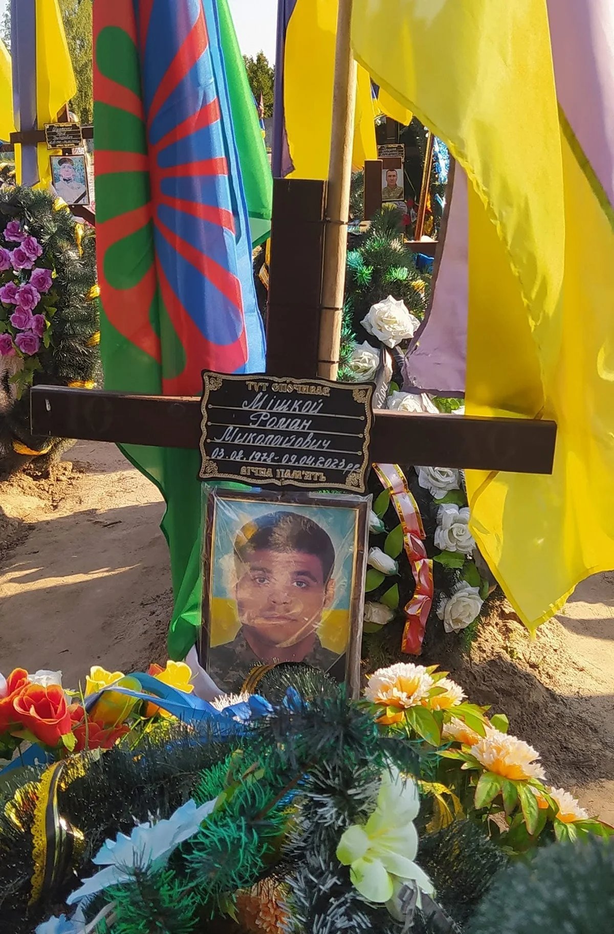 Two flags, Ukrainian and Roma, are placed on the graves of fallen Roma soldiers. Photo: Olga Musafirova