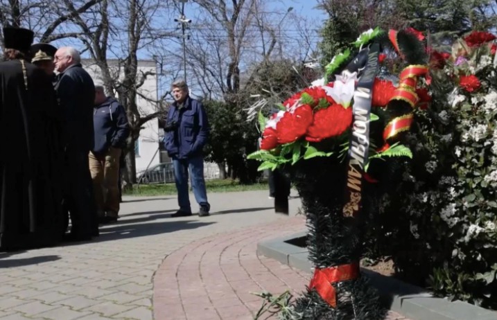 Wreath with a ribbon reading “To the ship and to the sailors”