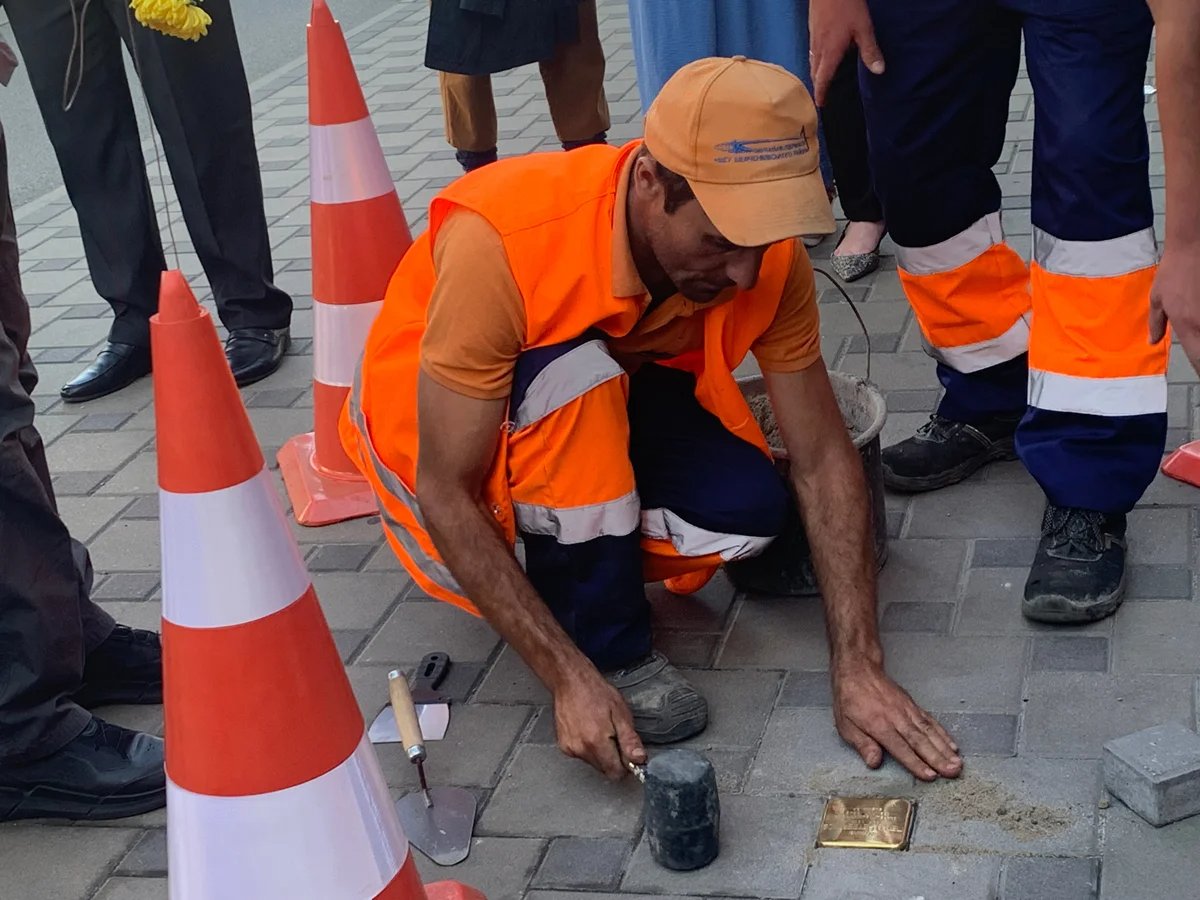 A workman embeds a Stolperstein into the pavement in Kyiv, Ukraine, 23 September 2025. Photo: Olga Musafirova