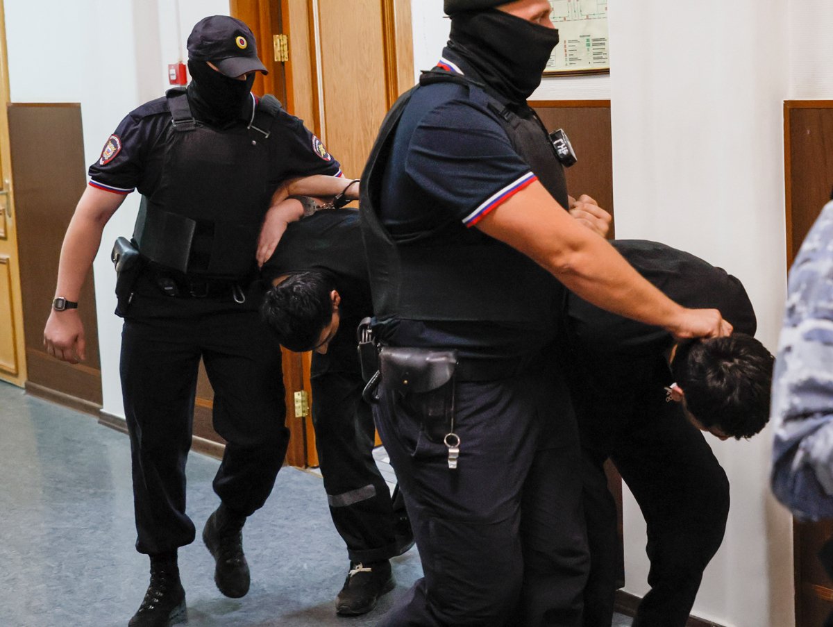 Сотрудники полиции сопровождают обвиняемых по делу о теракте в  Crocus City Hall  перед заседанием Басманного суда, Москва, 19 августа 2024 года. Фото: Юрий Кочетков / EPA