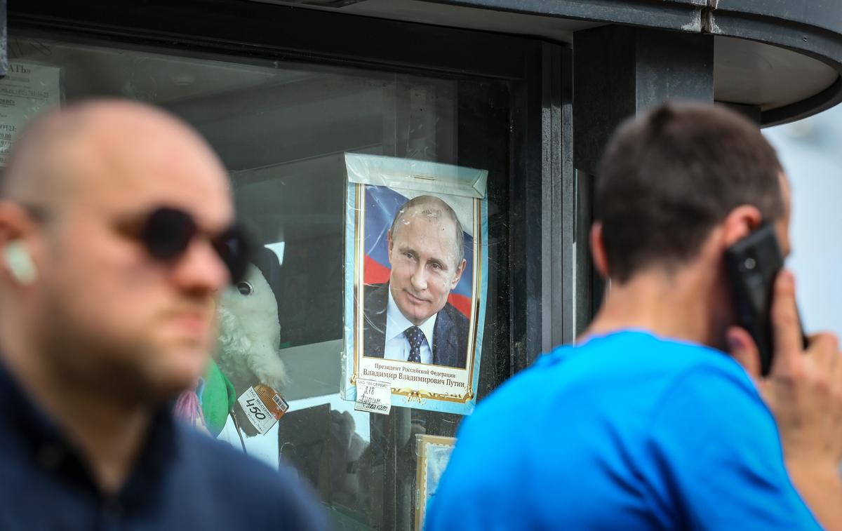 People walk past a Moscow street kiosk selling portraits of Vladimir Putin, 25 June 2025. Photo: EPA/YURI KOCHETKOV