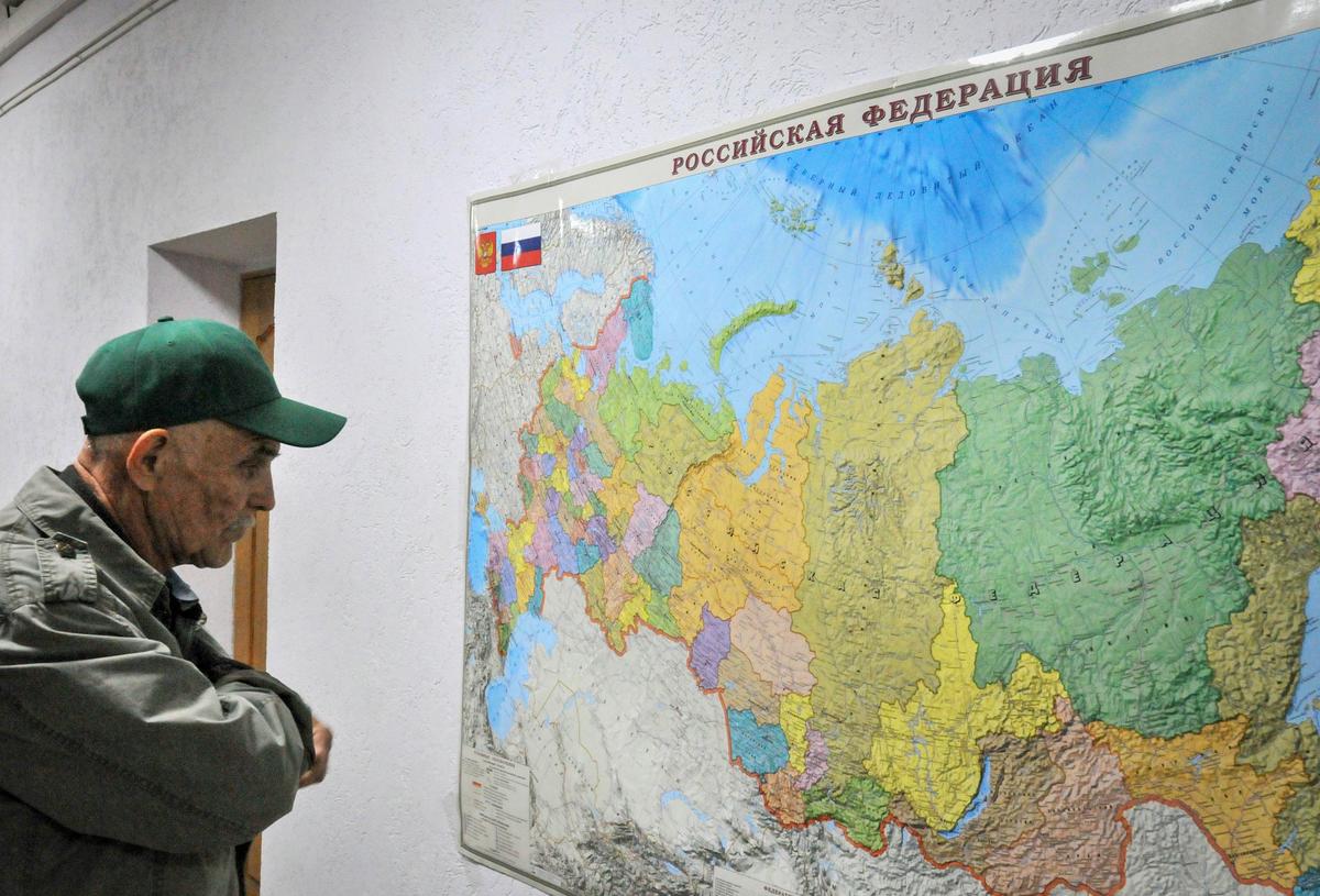 A man examines a map of Russia in an accommodation centre for refugees from Mariupol in Taganrog, in southern Russia’s Rostov region, 22 April 2022. Photo: EPA-EFE / ARKADY BUDNITSKY