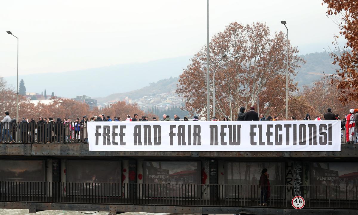 Georgian protesters display a banner during an anti-government rally in Tbilisi, Georgia, 28 December 2024. Photo: EPA-EFE / DAVID MDZINARISHVILI