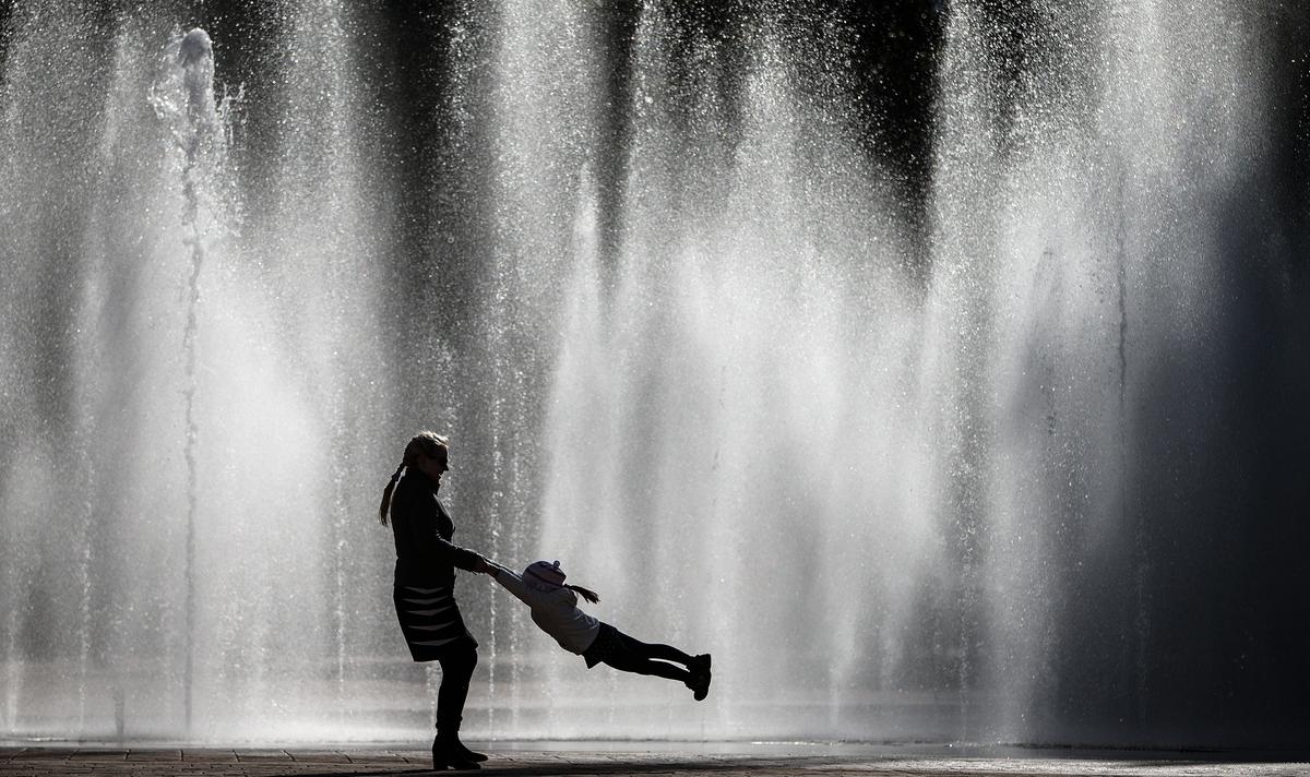 A mother plays with her child in a fountain in Sochi. Photo: EPA / Hannibal Hanschke