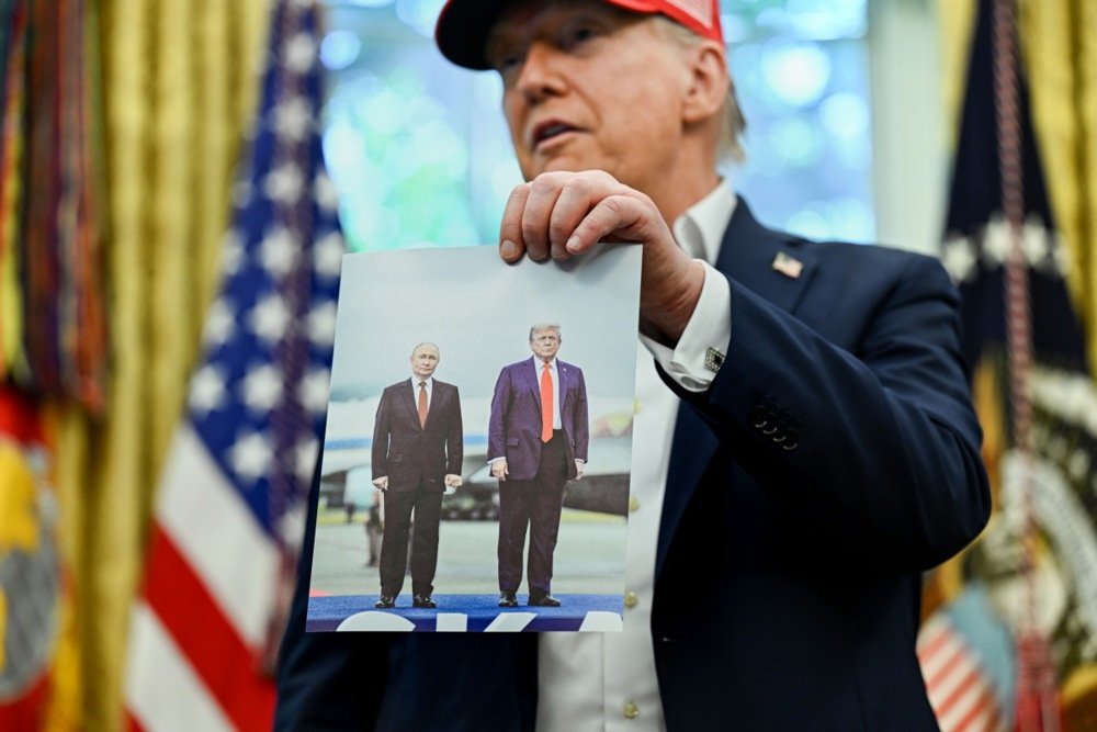 US President Donald Trump holds a photo of him with Vladimir Putin in the Oval Office of the White House in Washington, DC, USA, 22 August 2025. Photo: EPA/ANNABELLE GORDON / POOL
